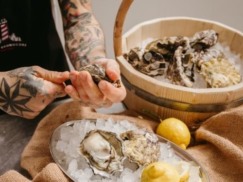 Immagine di Nello Buonocore intento ad aprire le ostriche