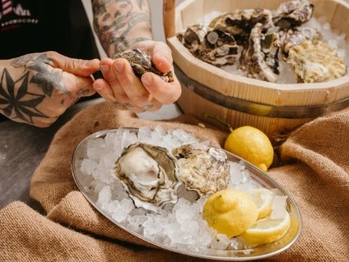 Ostriche aperte in piatto con ghiaccio e limone