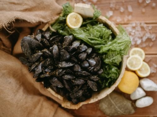 Cozze in contenitore con insalata e limone