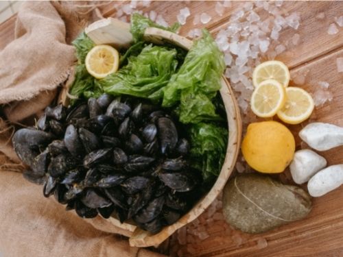 Cozze in una scodella con limone e insalata
