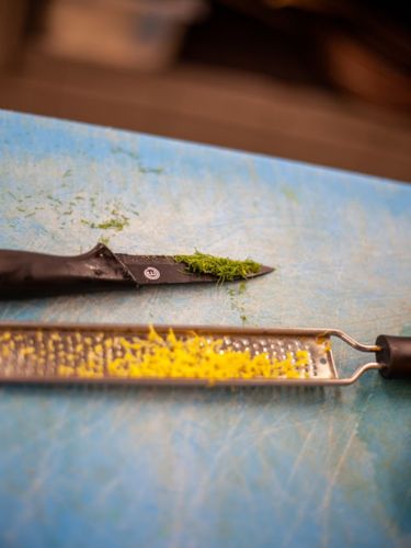 Coltello e grattugia sporca di buccia di limone